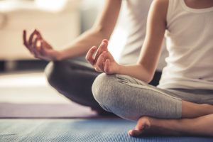 a group meditates in a yoga therapy program for addiction treatment